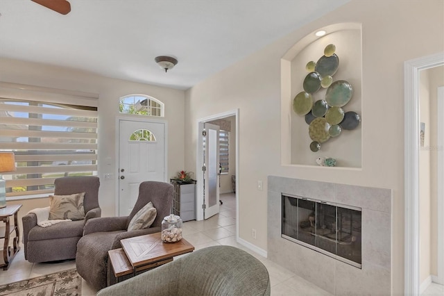 living area with light tile patterned floors, a fireplace, and baseboards