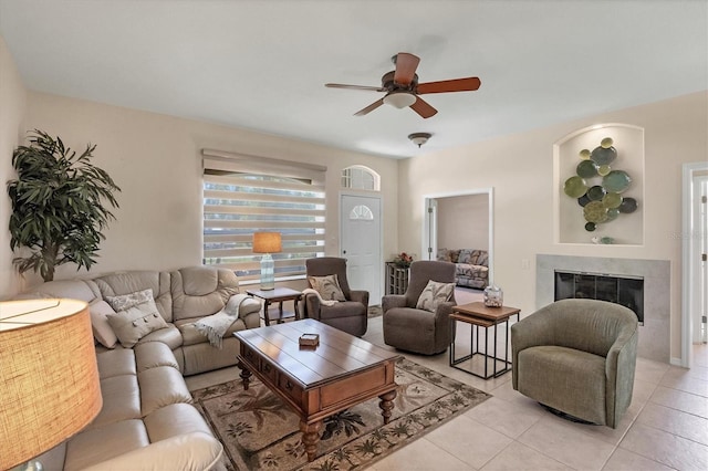 living area with a ceiling fan, light tile patterned floors, and a fireplace