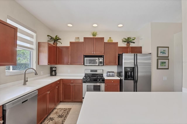 kitchen with light countertops, light tile patterned floors, recessed lighting, appliances with stainless steel finishes, and a sink