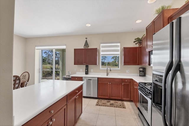 kitchen with a sink, light countertops, a wealth of natural light, and stainless steel appliances