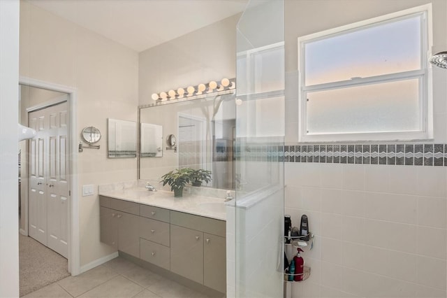 full bathroom featuring a sink, double vanity, tile patterned floors, and walk in shower