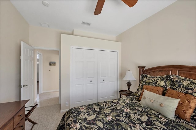 bedroom with a closet, visible vents, light colored carpet, and a ceiling fan