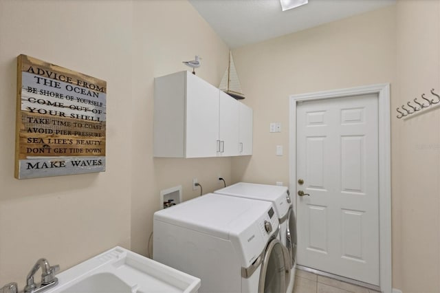 washroom featuring washer and clothes dryer, light tile patterned floors, cabinet space, and a sink