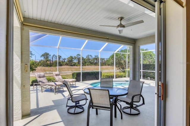 sunroom / solarium featuring a ceiling fan