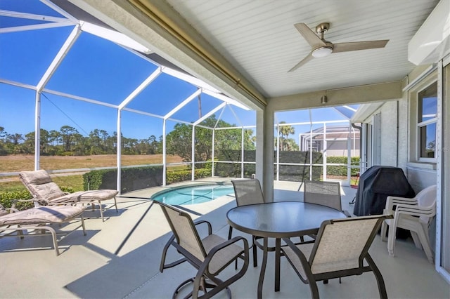 view of patio with glass enclosure, a ceiling fan, and an outdoor pool