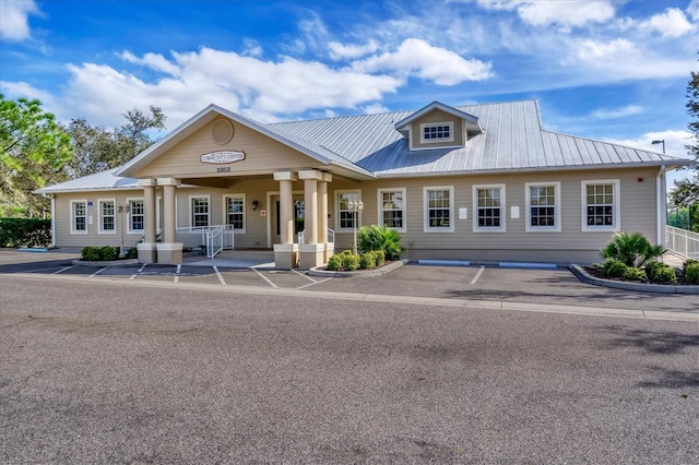 view of front of property with metal roof and uncovered parking