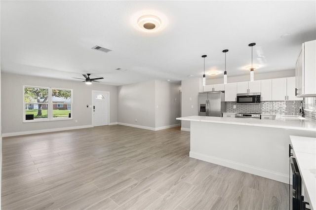 kitchen featuring visible vents, stainless steel fridge, decorative backsplash, and light countertops