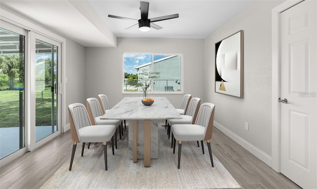 dining area with baseboards and light wood-style flooring