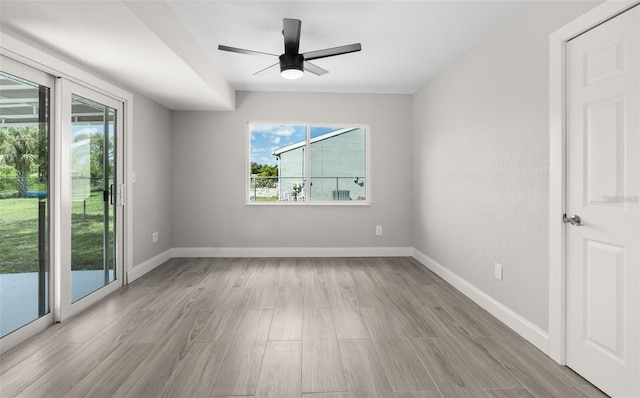 unfurnished room with light wood-style flooring, a ceiling fan, and baseboards