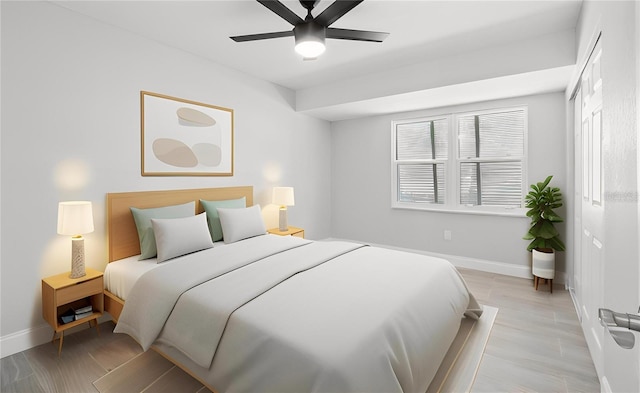 bedroom with a ceiling fan, light wood-style floors, and baseboards