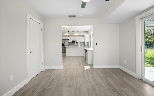 interior space with light wood-style flooring, baseboards, and visible vents