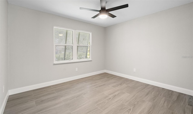 empty room with ceiling fan, light wood-style flooring, and baseboards