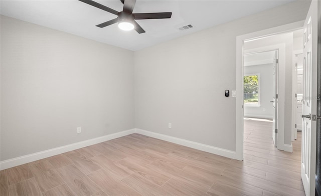 spare room with a ceiling fan, light wood-style flooring, baseboards, and visible vents