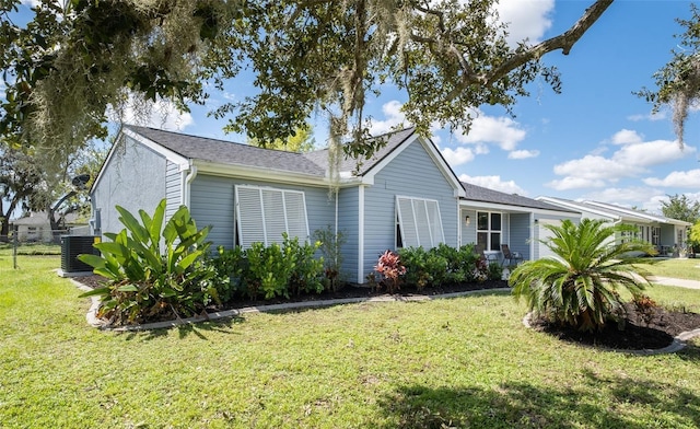 view of front of home with a front yard and central AC unit