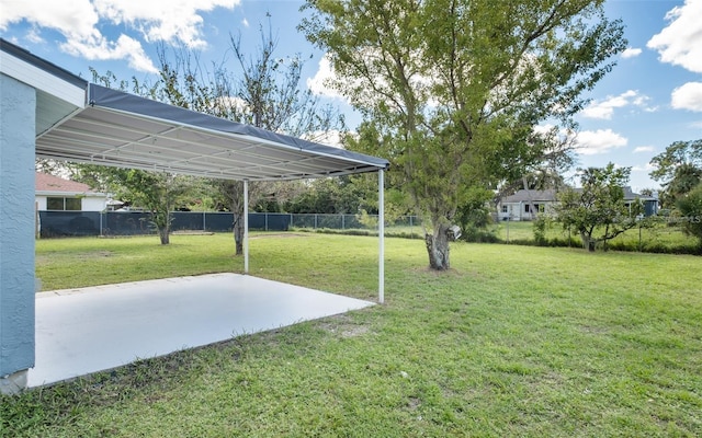 view of yard featuring a patio area, a carport, and fence