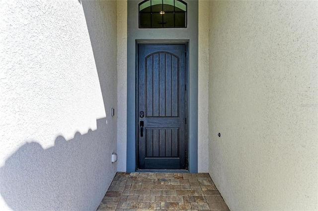 property entrance with stucco siding