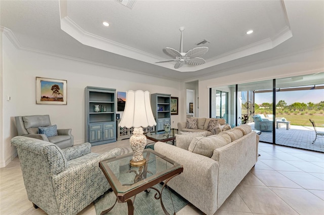 living room with a tray ceiling, crown molding, and visible vents