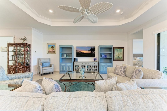 living room with wood finished floors, a raised ceiling, ornamental molding, and a ceiling fan