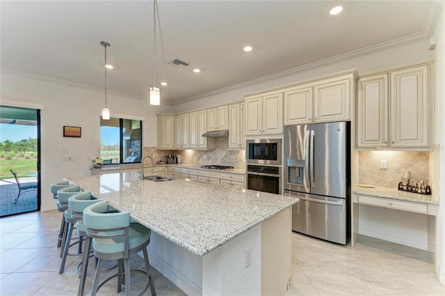 kitchen with cream cabinets, visible vents, appliances with stainless steel finishes, and a sink