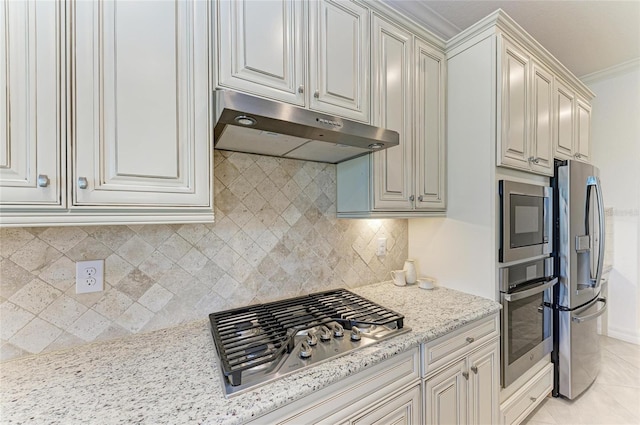 kitchen with light stone counters, light tile patterned floors, stainless steel appliances, under cabinet range hood, and backsplash