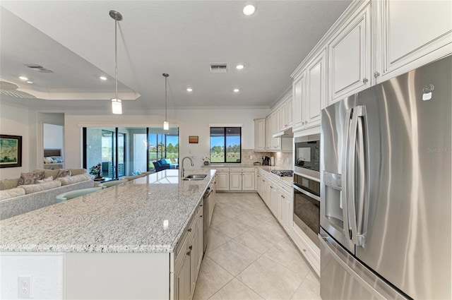 kitchen featuring a large island, visible vents, stainless steel appliances, and a sink