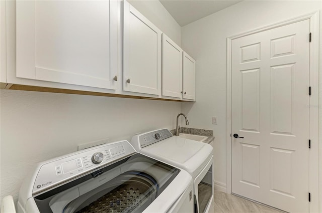 laundry area with a sink, cabinet space, and washing machine and clothes dryer