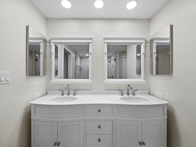 bathroom featuring double vanity, recessed lighting, and a sink