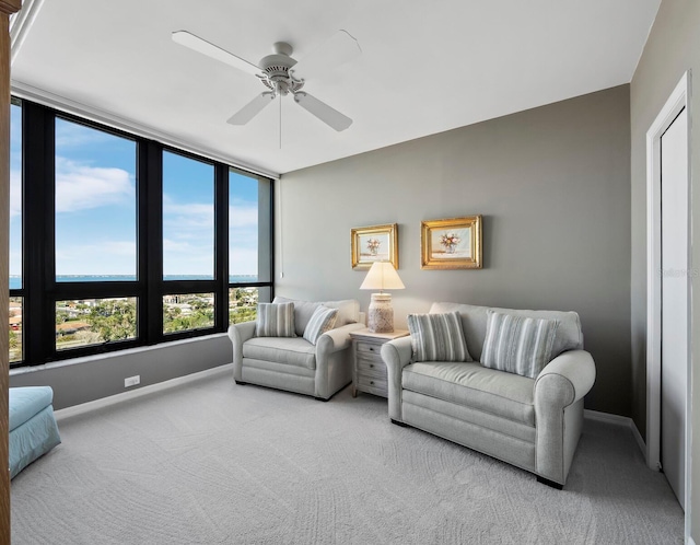 living area with carpet flooring, ceiling fan, and baseboards