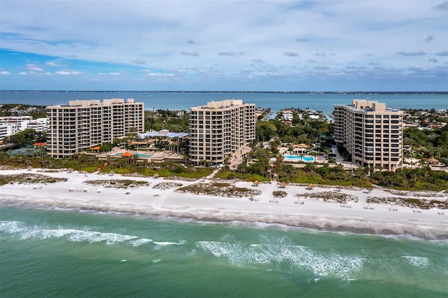 drone / aerial view with a water view, a city view, and a beach view