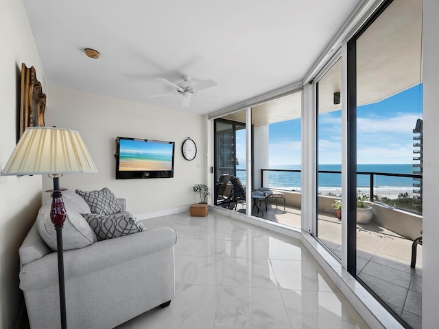 living room with a wealth of natural light, expansive windows, baseboards, and a ceiling fan