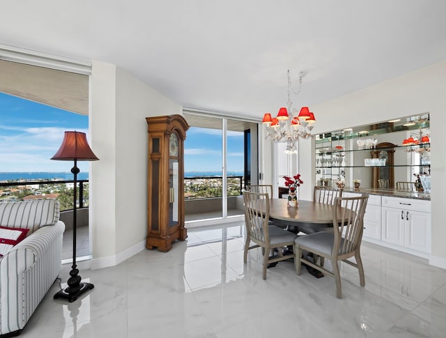 dining room featuring a notable chandelier, baseboards, and expansive windows