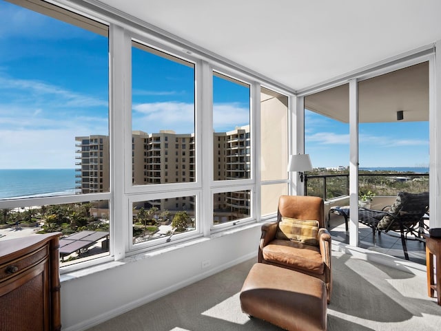 sunroom featuring a water view