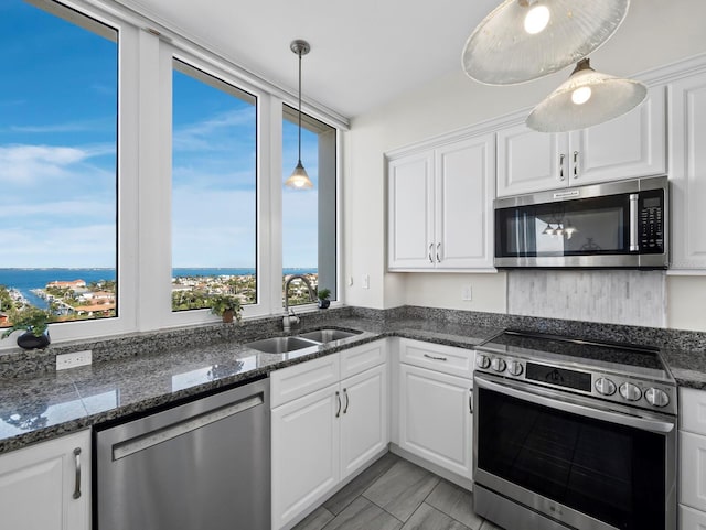 kitchen featuring a sink, stainless steel appliances, pendant lighting, and white cabinets