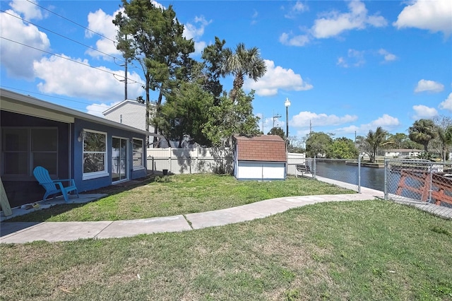 view of yard with an outbuilding, a storage unit, and fence