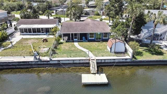 exterior space with a fenced backyard, a lawn, and a water view