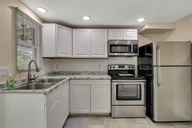 kitchen featuring a sink, light countertops, appliances with stainless steel finishes, and white cabinets