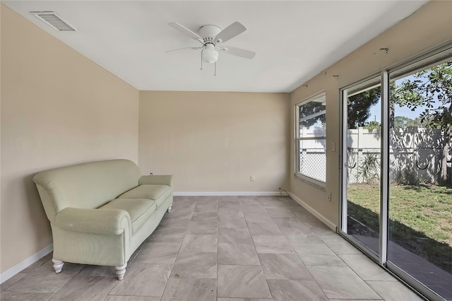 living area featuring a ceiling fan, baseboards, lofted ceiling, and visible vents
