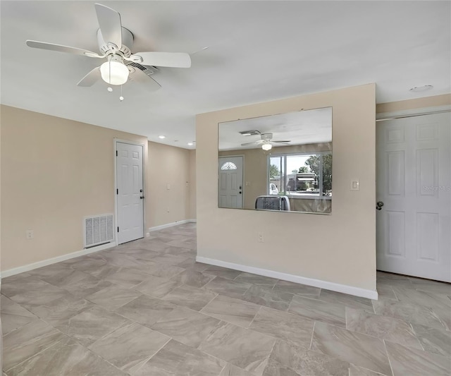 empty room with baseboards, visible vents, and a ceiling fan
