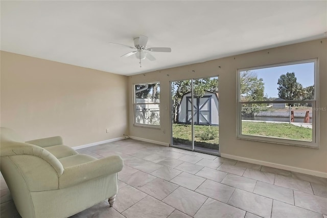 sitting room with tile patterned flooring, baseboards, and ceiling fan