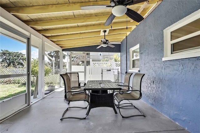 sunroom / solarium featuring beamed ceiling, ceiling fan, and outdoor dining space