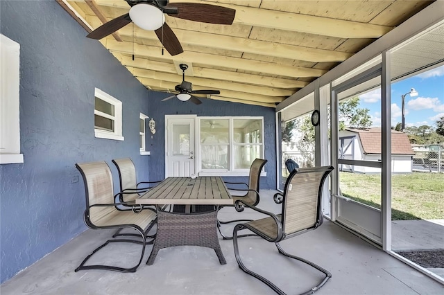 sunroom / solarium with beamed ceiling and a ceiling fan