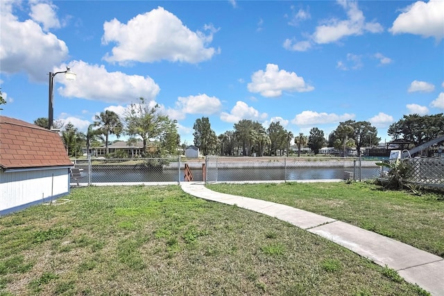 view of yard featuring a gate, a water view, and fence
