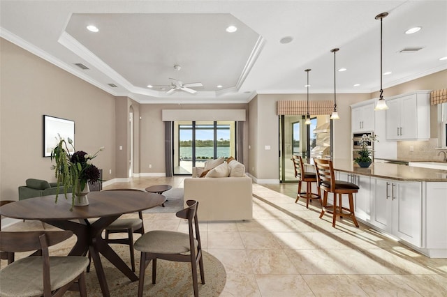 dining room featuring recessed lighting, a raised ceiling, baseboards, and ornamental molding