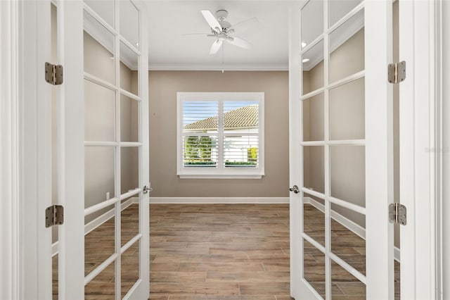 walk in closet with french doors, wood finished floors, and a ceiling fan