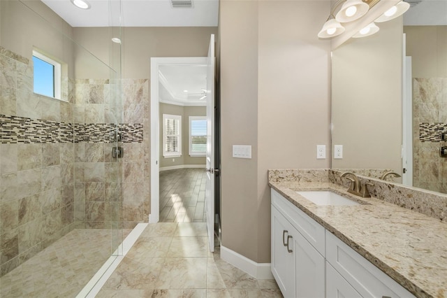 bathroom with a wealth of natural light, a walk in shower, and vanity