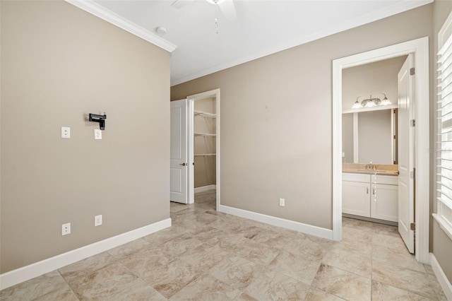 unfurnished bedroom featuring a spacious closet, connected bathroom, baseboards, and ornamental molding