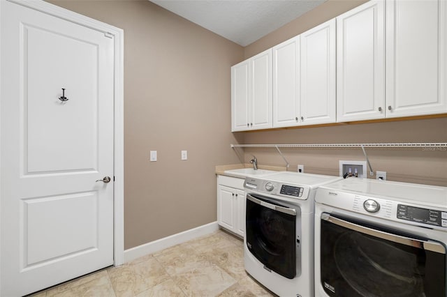 laundry room featuring a sink, baseboards, cabinet space, and washer and clothes dryer