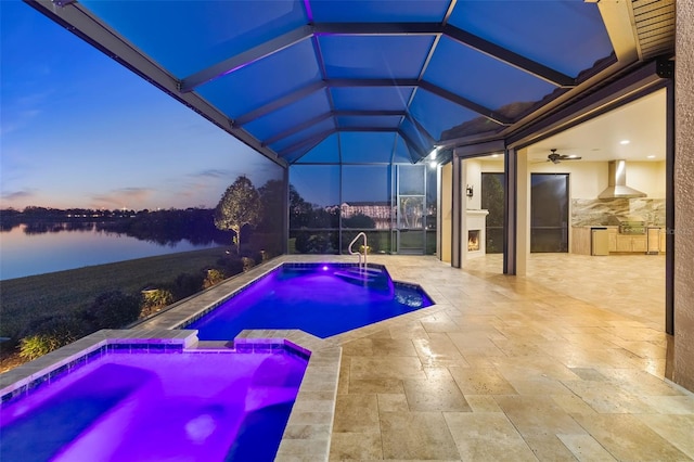 outdoor pool featuring a patio, an in ground hot tub, area for grilling, a water view, and a lanai