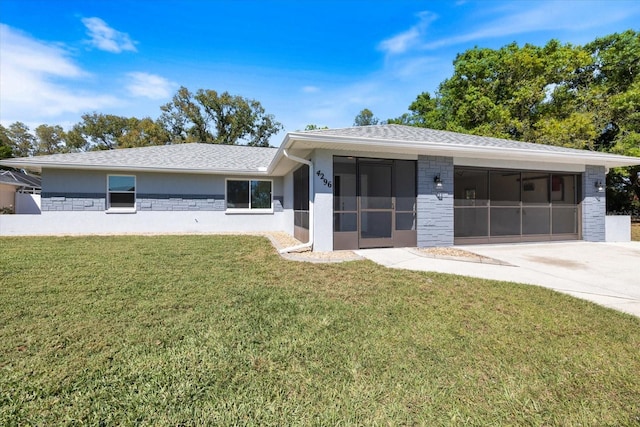 view of front of house with stucco siding, a front lawn, roof with shingles, and driveway