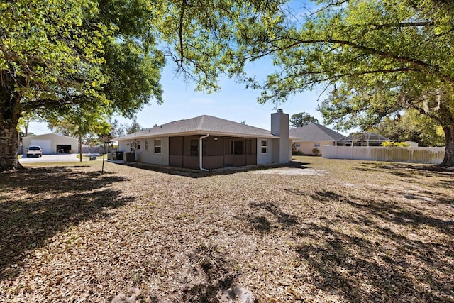 rear view of property with fence, a sunroom, and a chimney